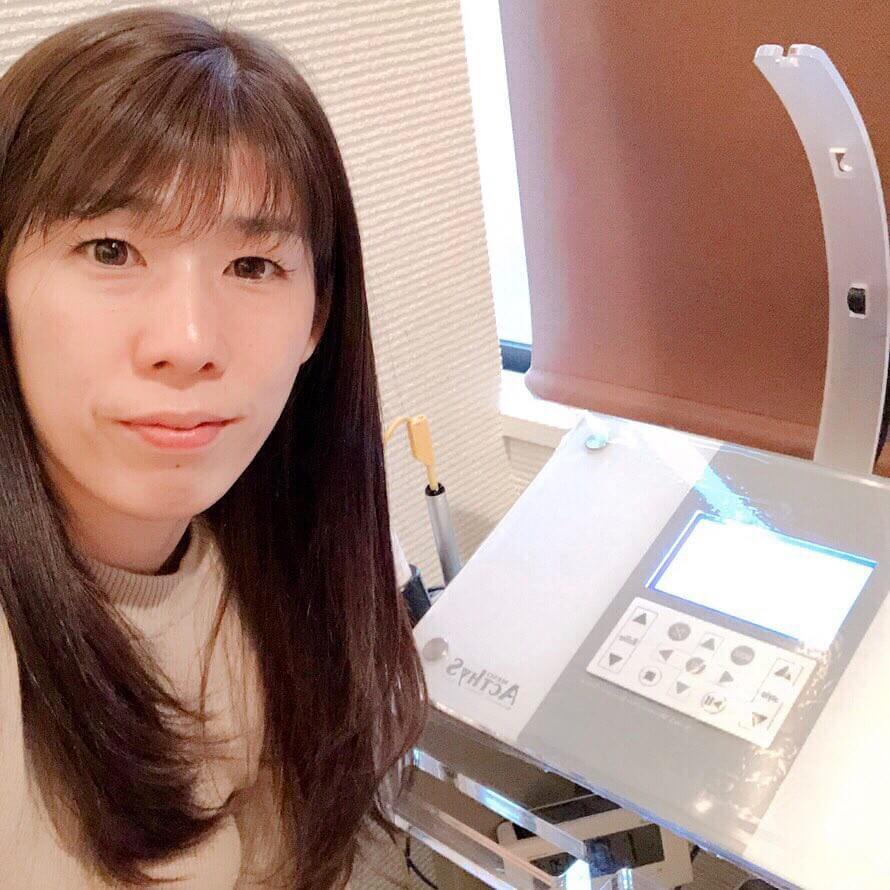 エステの機械の前に座る吉田さん