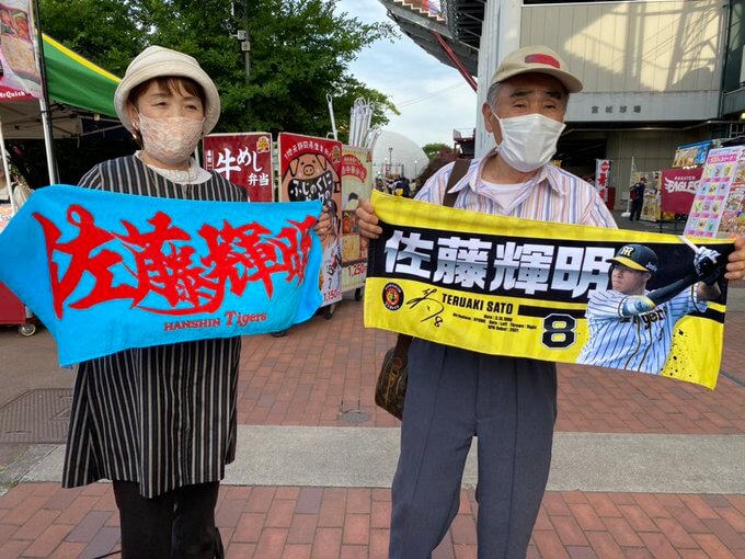 タオルを広げて応援する祖父母