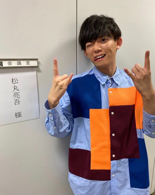 楽屋前おどけたポーズをする松丸亮吾