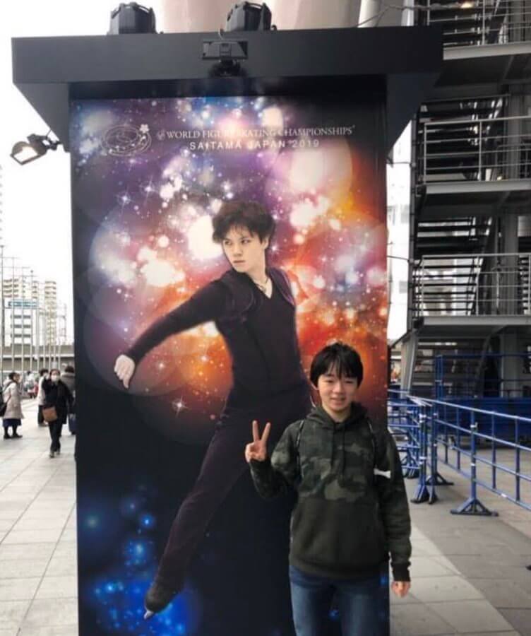 宇野昌磨の等身大パネルの前で笑顔でピースをして写真を撮る鍵山優真