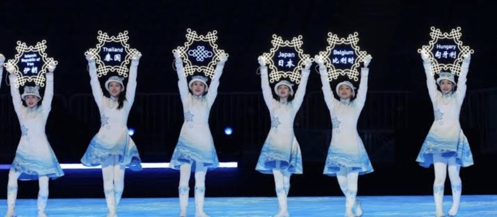 北京オリンピックで雪の結晶のプラカードをもつかわいい衣装と虎の帽子をかぶった美女がダンスしているところ